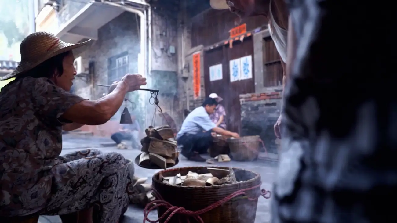 A woman weighs up agarwood at a market in China.