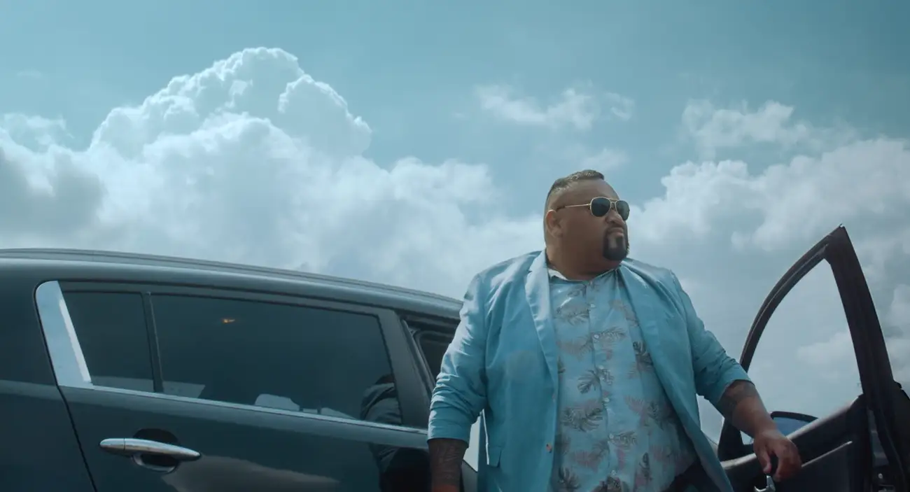 Comedian Tofiga Fepulea'i as Bob Titilo, steps out of a car, smartly dressed in a sky-blue suit.